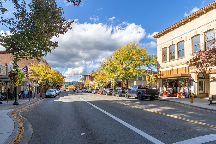 About Our Agency - View of Main Street Sidewalks and Stores in Downtown London Kentucky on a Sunny Day with Green Trees Along the Road